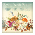 A FLYING WISH PAPER® package features a dragonfly, mushrooms, ferns, and flowers. Instructions: Write it, Light it, Watch it Fly using the wish-launching platform. A mindful Flying Wish Paper® kit to help make your wishes come true.