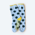 The Hooray Sock Co. Clipper Sock is a unisex crew sock in light blue with large black polka dots, yellow cuffs, heels, and toes, shown overlapping on a plain light background.