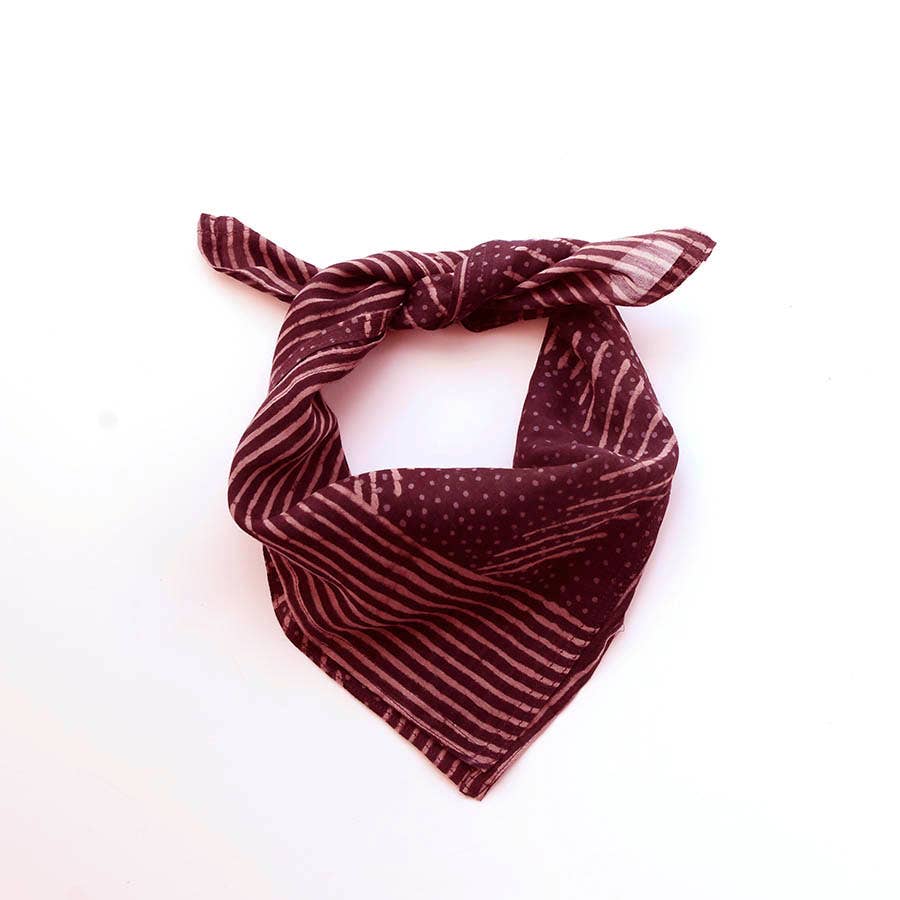 The Ichcha Square Bandana Scarf Artisan Block Print Ladies in violet is shown tied loosely, highlighting its stripe and dot patterns against a plain white background.