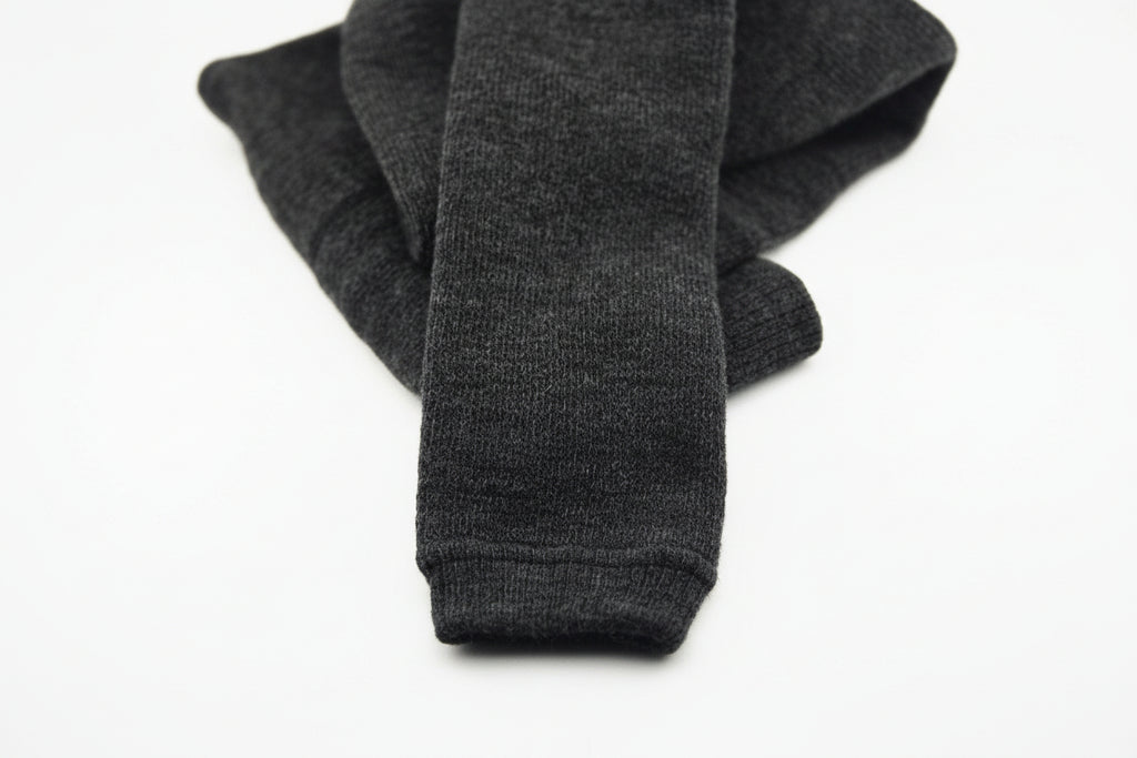 A pair of dark gray, folded Choice Alpaca Products Alpaca Leggings is displayed on a plain white background, known for their temperature regulating and moisture wicking properties.