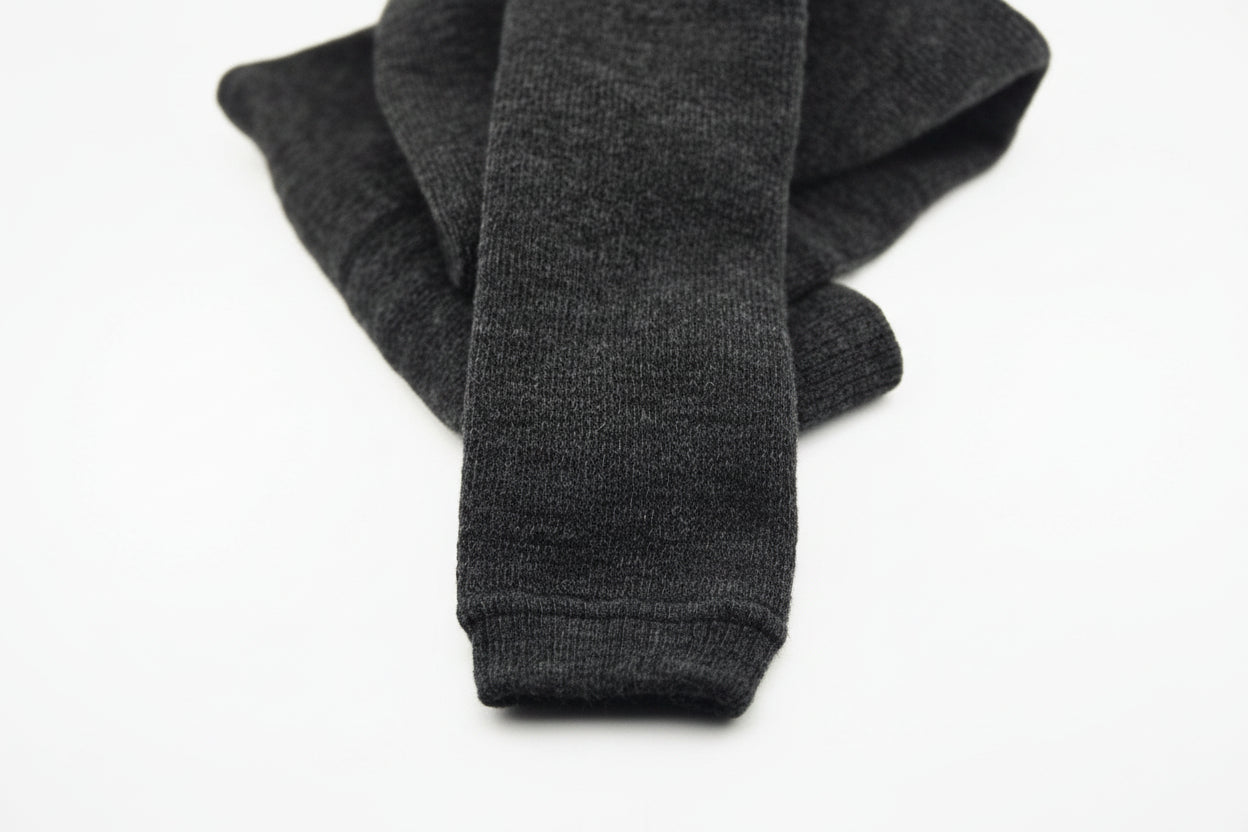 A pair of dark gray, folded Choice Alpaca Products Alpaca Leggings is displayed on a plain white background, known for their temperature regulating and moisture wicking properties.