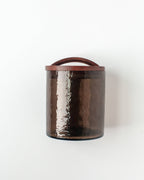 The Handblown Hammered Glass Canisters: Blush / Medium by Creative Women features a blush-toned, textured glass body with a hand-carved wooden lid, shown against a white background.