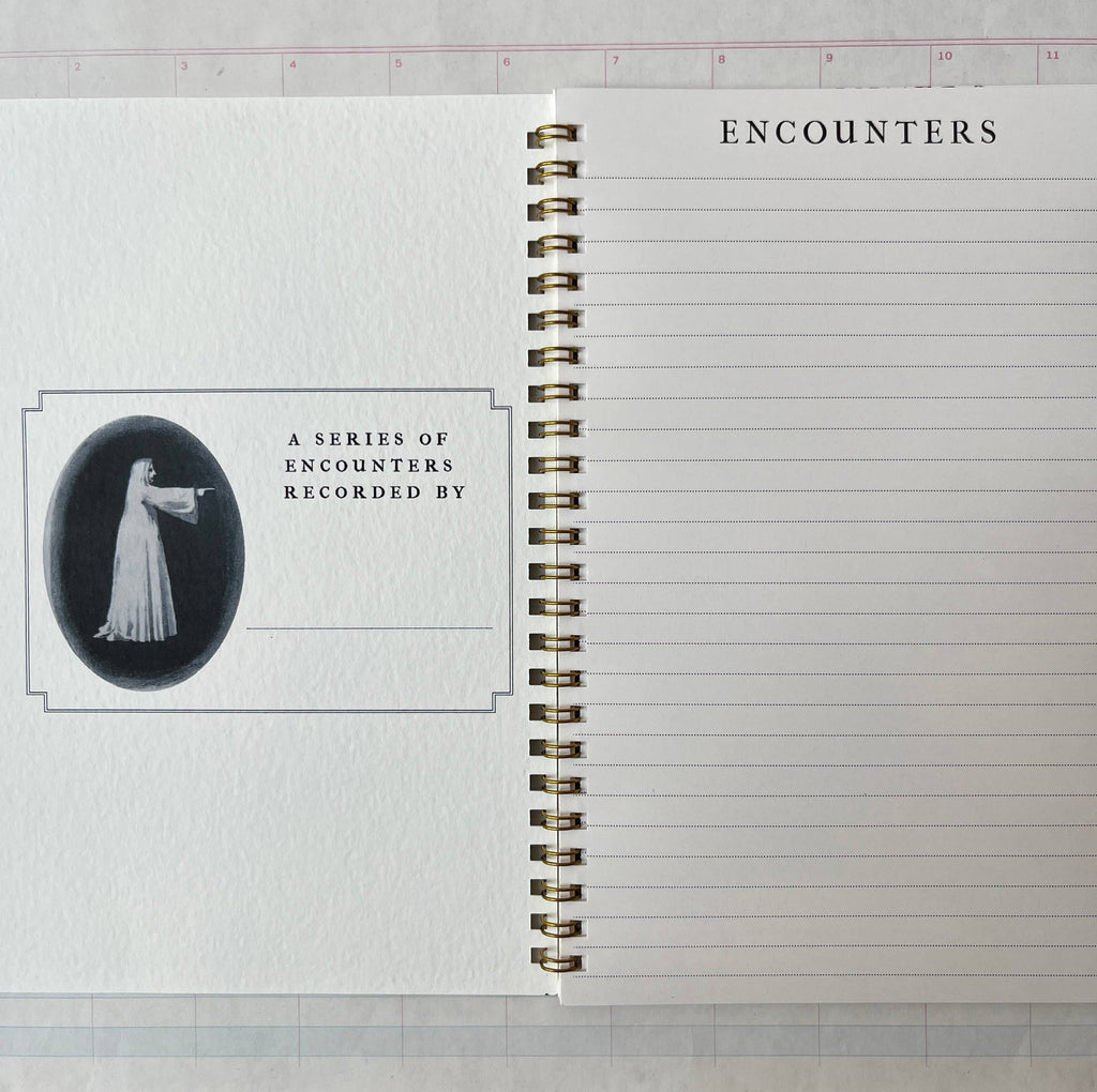 The open Spectropia, Spectral Illusions and Ghosts journal by Parcel has lined pages: "ENCOUNTERS" tops the right page, while the left shows a vintage woman in white above "A SERIES OF ENCOUNTERS RECORDED BY" with space to write below.