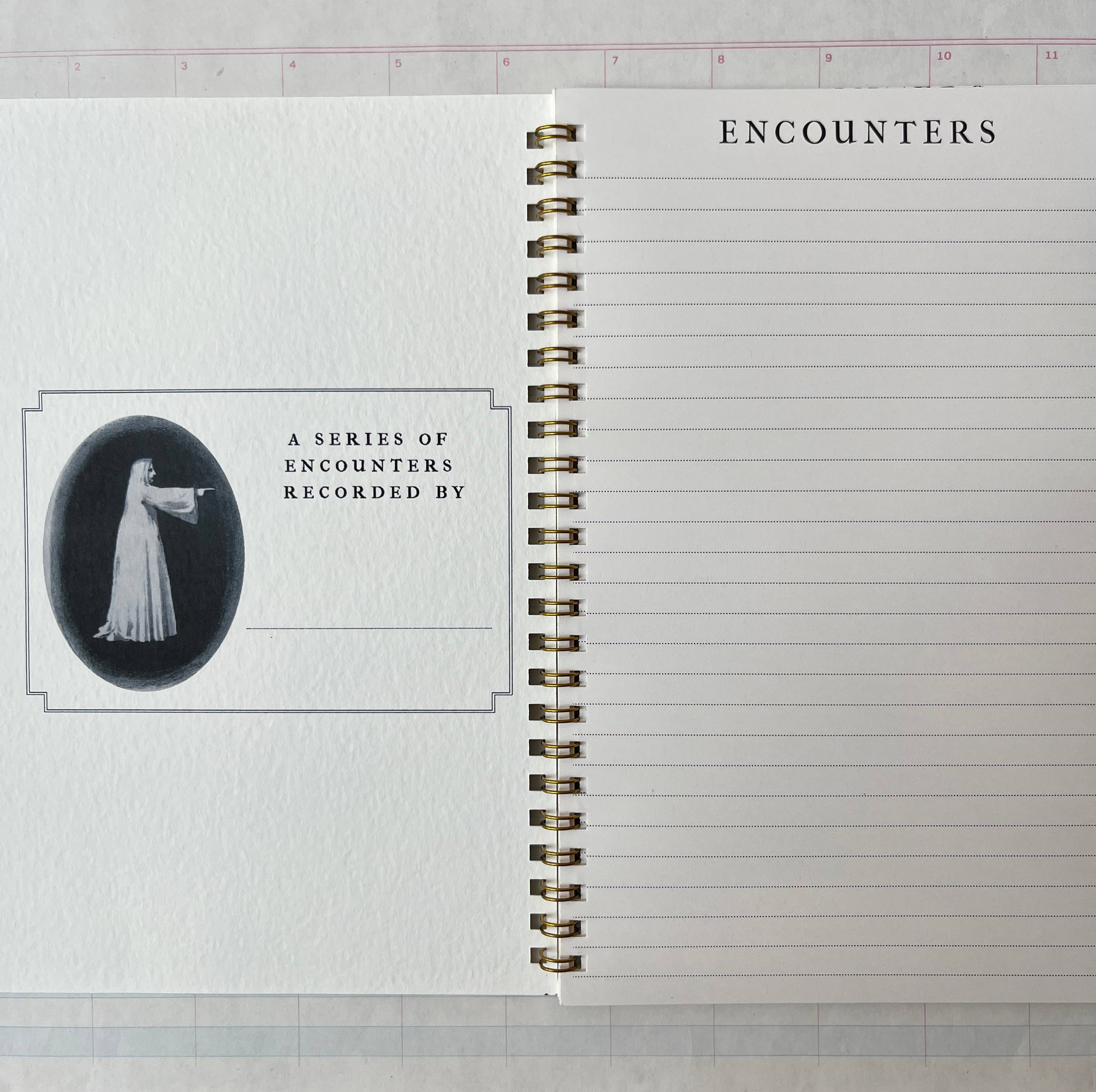 The open Spectropia, Spectral Illusions and Ghosts journal by Parcel has lined pages: "ENCOUNTERS" tops the right page, while the left shows a vintage woman in white above "A SERIES OF ENCOUNTERS RECORDED BY" with space to write below.