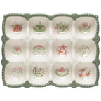 The Camellia Egg Holder by Danica Heirloom is a stoneware crate with green edges and twelve sections, each adorned with red or green hand-drawn flowers, leaves, or dragonflies—ideal for a charming kitchen display.