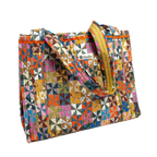 The Calico Quilted Tote by Handker Bandanas features vibrant patchwork, two sturdy handles, and a small Handker label on the front for a colorful, stylish look.