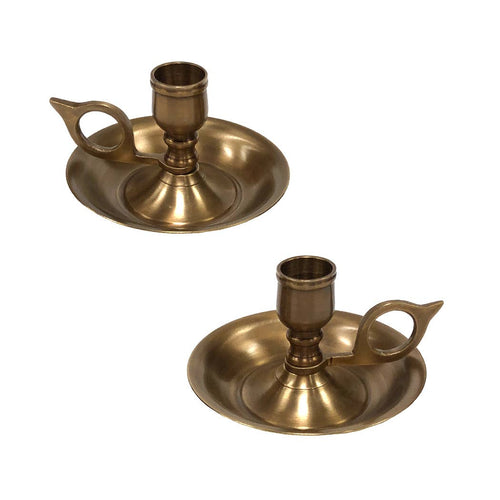 The Madison Bay Co. Brighton Bun Traveling Chamberstick Set features two vintage-style brass chambersticks with round drip trays and looped handles, inspired by antique originals, displayed on a white background.