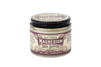 A glass jar of Roots And Leaves Magnesium Body Butter features extra strength, unrefined shea, cocoa, and mango butters for optimal magnesium absorption. The purple and cream labels on the lid and front are clearly visible.