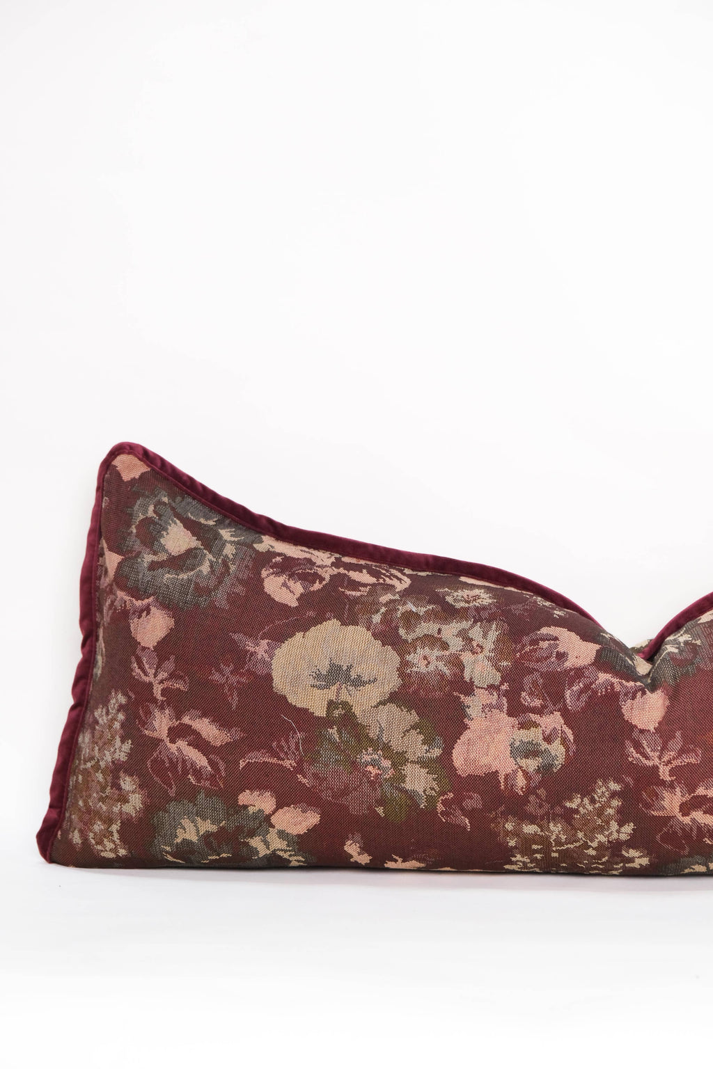 The Tapestry Long Lumbar by Twenty Third by Deanne is a rectangular pillow featuring a burgundy botanical tapestry design with tan, green, and pink florals on a plain white background.