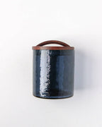 The Handblown Hammered Glass Canisters: Blush / Medium by Creative Women features blush hammered glass with a rounded, hand-carved wooden lid, displayed upright on a white background.