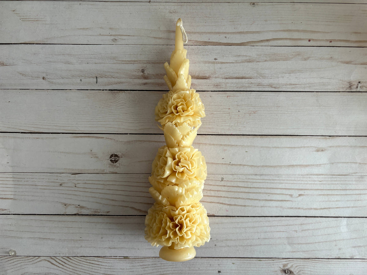 Ivory Large Floral Oaxaca Marigold Day of the Dead Candle: a tall, tapered ivory beeswax candle sculpted with stacked marigold flowers in the style of traditional Oaxaca candles.