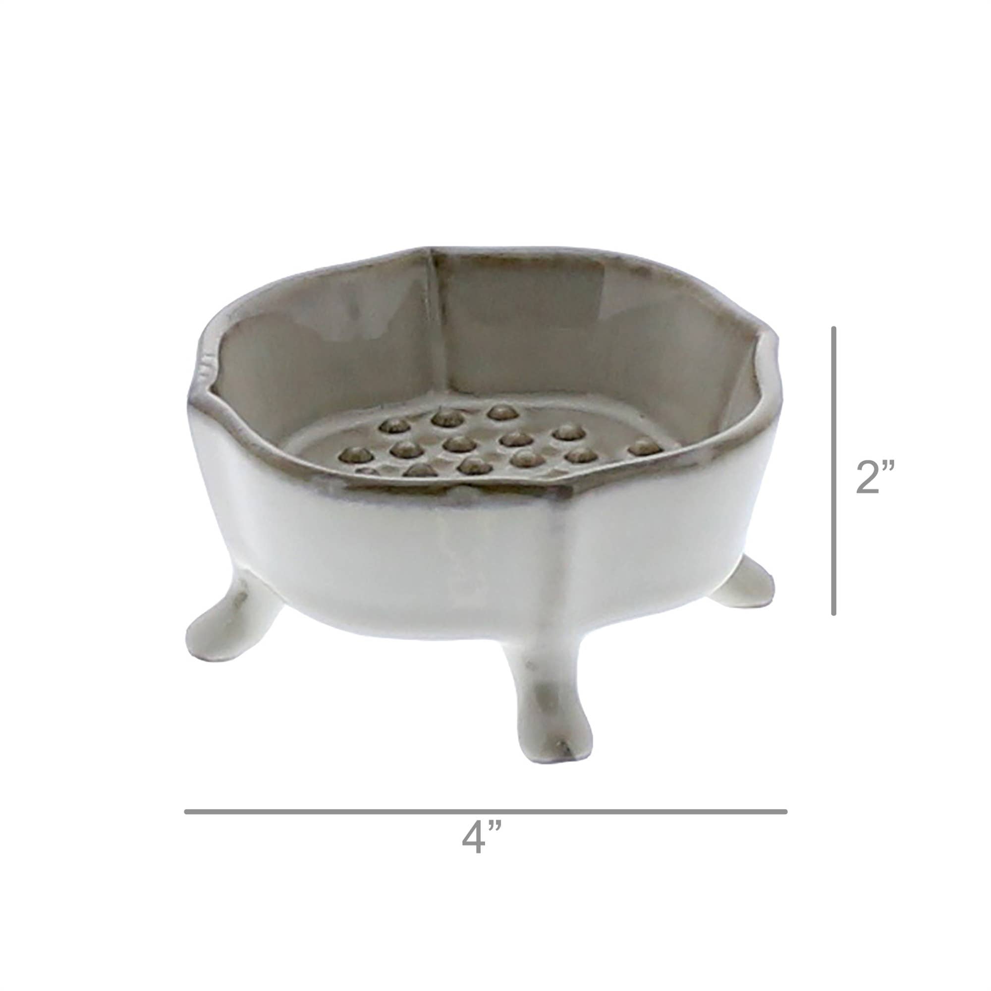 The HomArt Ceramic Rue Footed Soap Dish - Fancy White features three short legs, a scalloped edge, and a raised platform with holes. Measuring 4" wide by 2" tall, it's a charming bathroom accessory for any space.