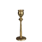 The HomArt Sonrisa Taper Holder, Brass - Sm, is a single fluted metal candlestick holder with a textured surface and wide round base, shown upright on a white background.