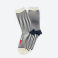 The Cole Black and White Striped Crew Socks by Hooray Sock Co. are unisex crew socks with cream toes, heels, and cuffs, plus small red and blue stripes near the toe on one sock. Perfect for any wardrobe. Set against a plain white background.