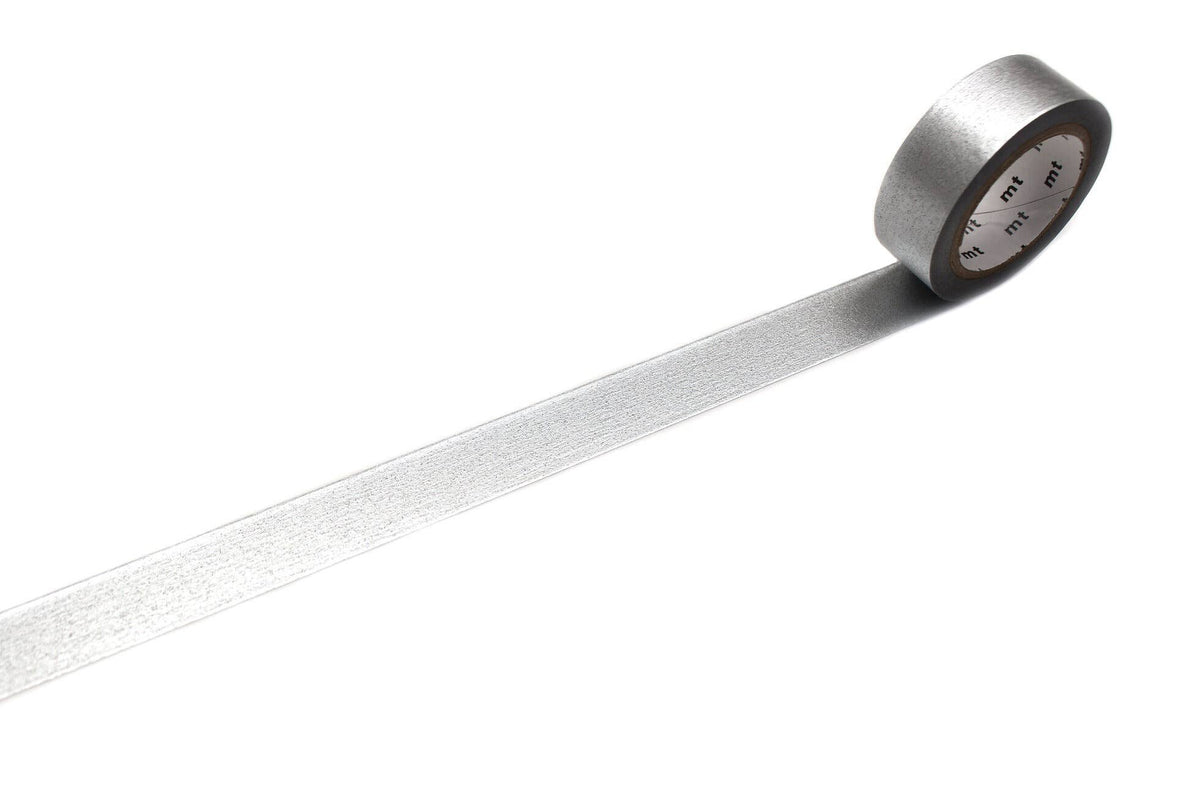 A roll of mt masking tape (Sweet Bella) High Brightness Silver washi tape with a strip unspooled across a white background.