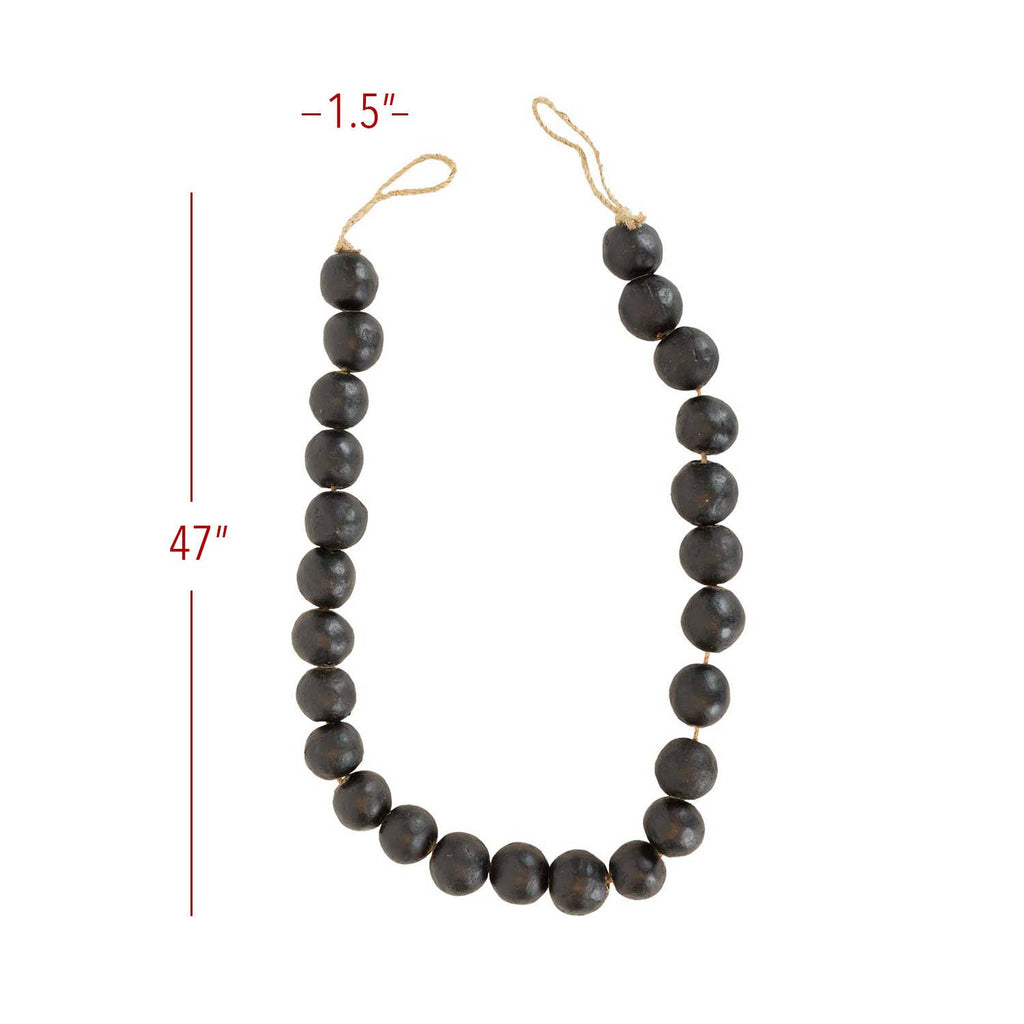 The Black Terracotta Bead + Jute Garland by Foreside Home & Garden features large, round dark beads (1.5" wide) strung on a tan jute cord, forming a 47" loop that adds handmade Indian-inspired decor to any space.