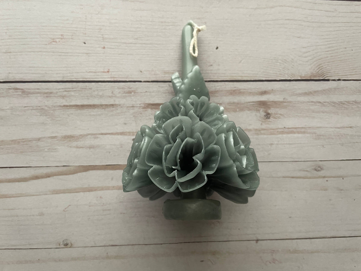 Sage Oaxaca Marigold Day of the Dead Candle, a sage green beeswax taper shaped like a bouquet of marigold flowers.