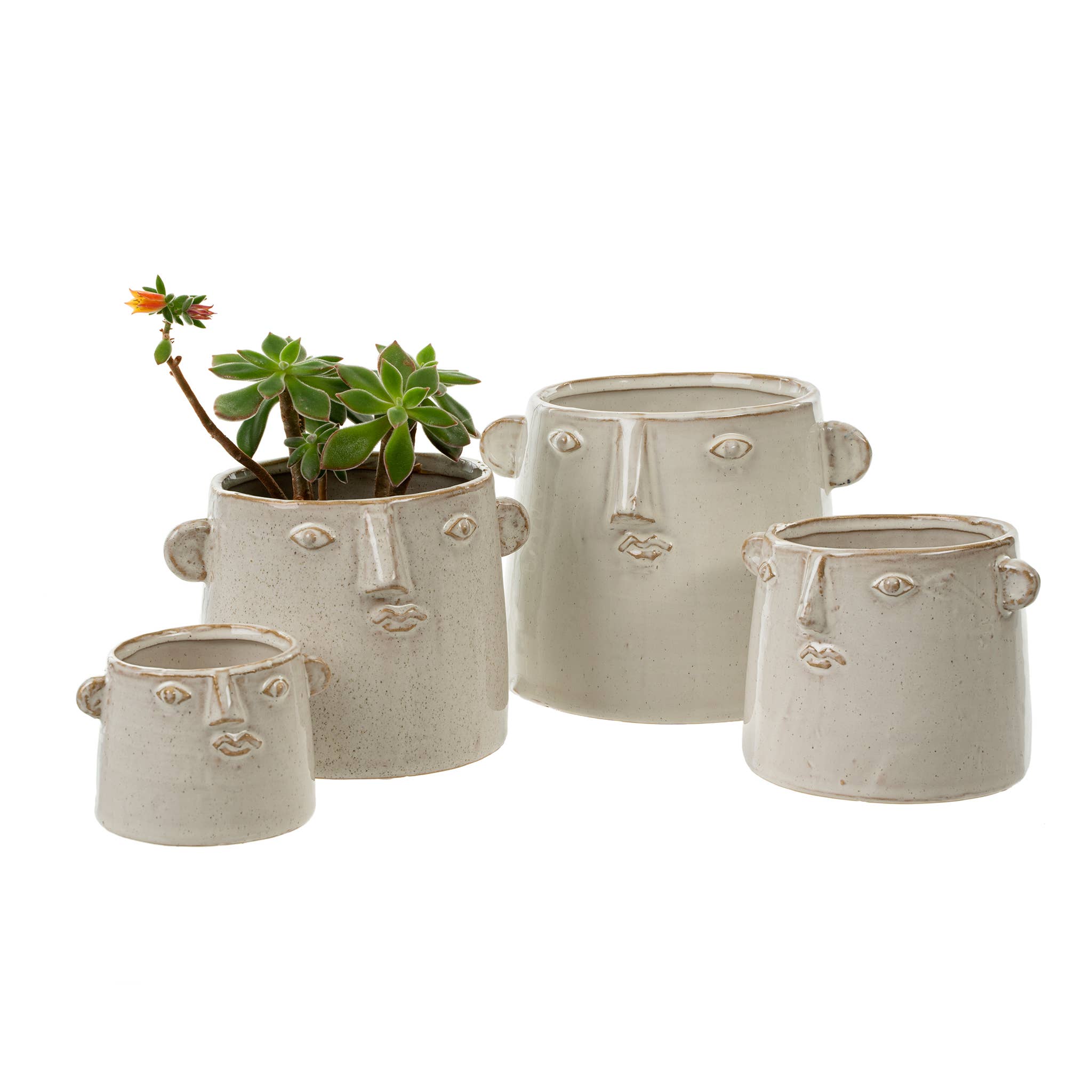 Four Indaba Trading Character Pot S ceramic planters, each shaped like a face with simple features, are grouped together. One mini succulent with yellow flowers sits in a pot, while the other pots remain empty.