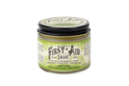 The Roots And Leaves First Aid Salve is an organic, petroleum-free ointment in a small glass jar with a black lid. It blends comfrey, calendula, manuka honey, and more natural ingredients, as highlighted on its decorative label.