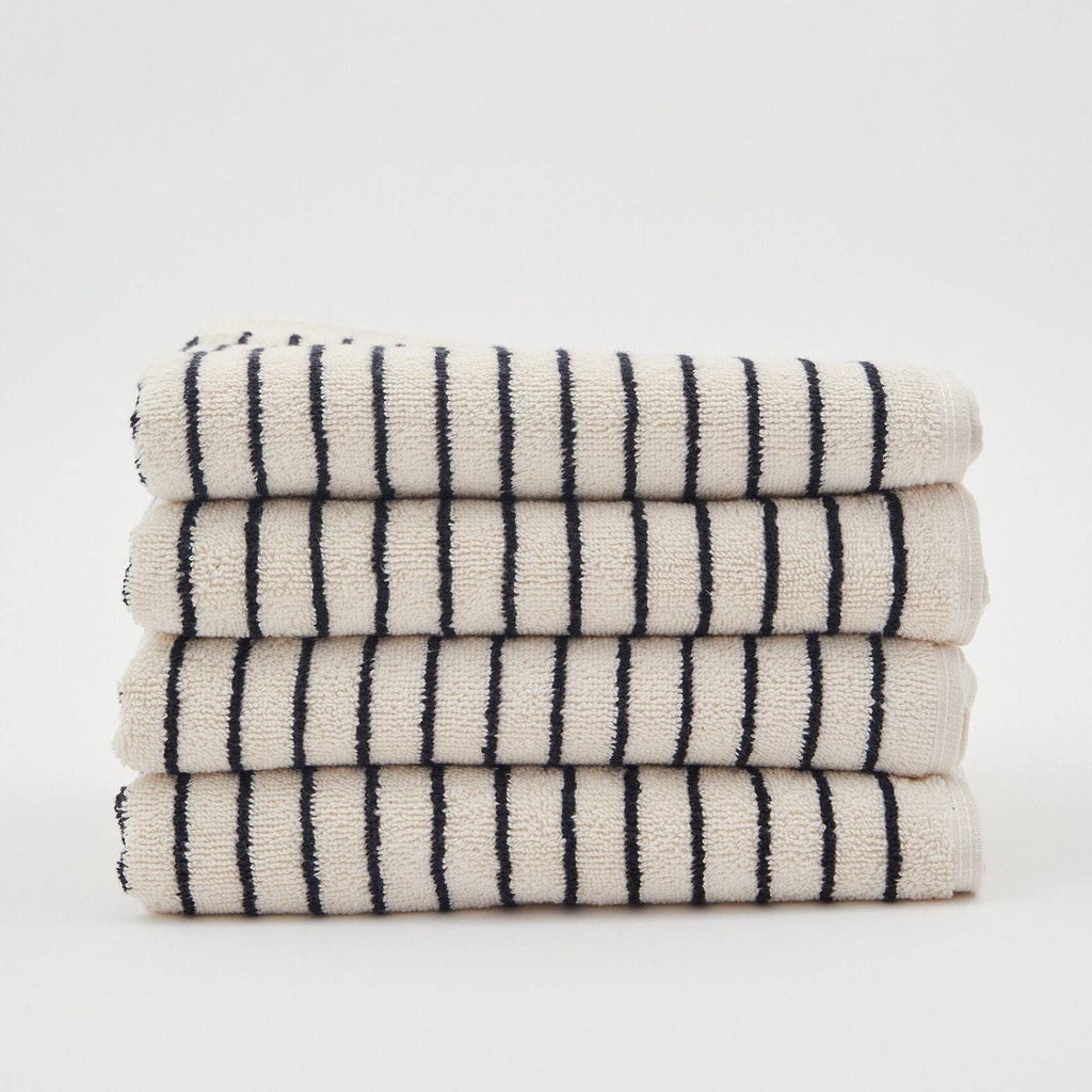 A neatly folded stack of four The Loomia Turkish Cotton Striped Terry Bath Sheets, OEKO-TEX certified in cream with black stripes, displayed against a plain white background.