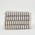 A neatly folded stack of four The Loomia Turkish Cotton Striped Terry Bath Sheets, OEKO-TEX certified in cream with black stripes, displayed against a plain white background.