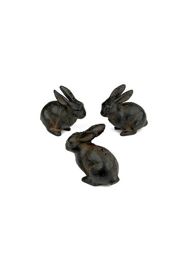 The Vagabond Vintage Small Cast Iron Rabbit figurines, with a rich brown finish, are displayed in a loose triangle on a white background—charming accents to enhance any decor.