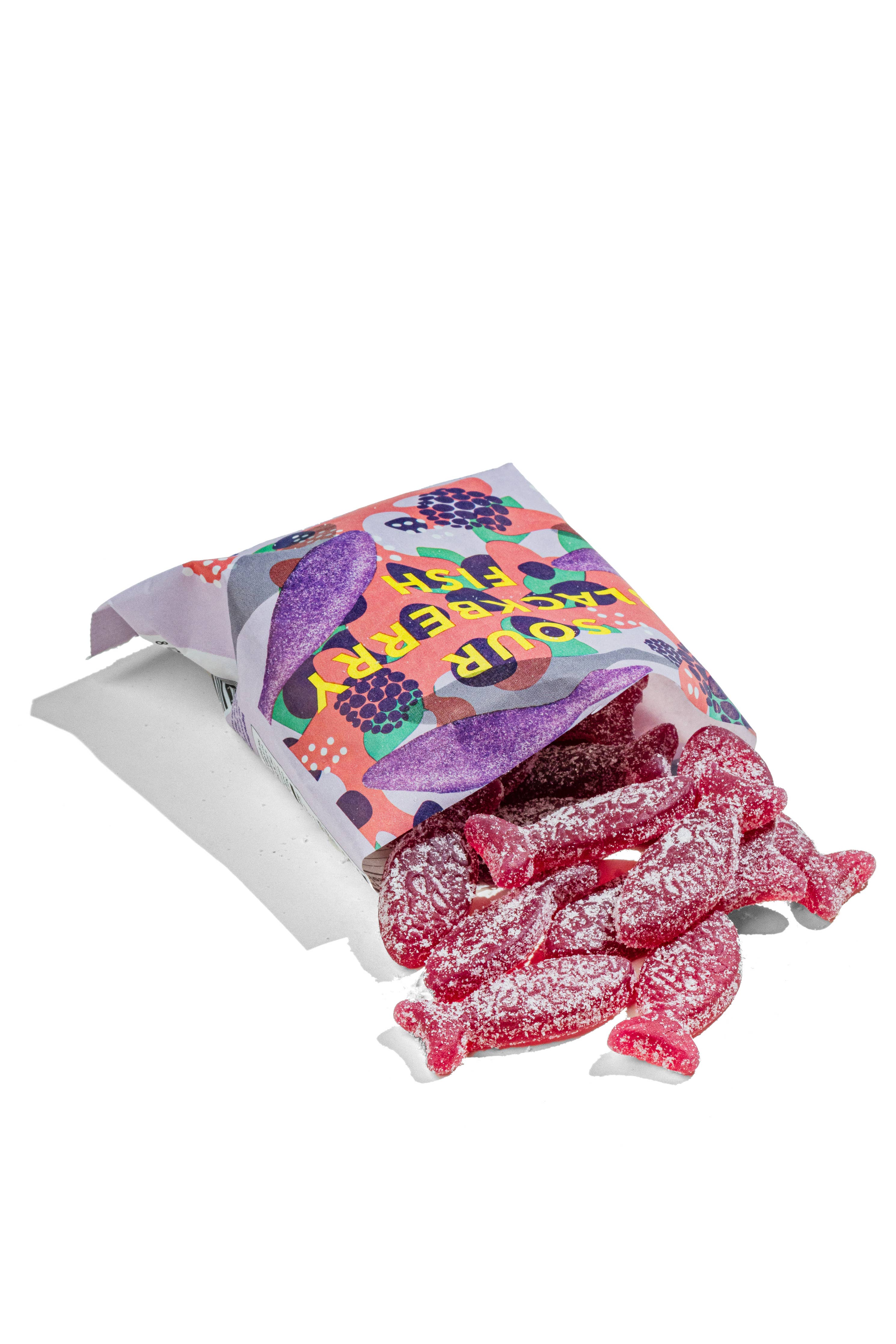 A vibrant bag of BonBon - A Swedish Candy Co Sour Blackberry Fish - Swedish Candy 5.2oz (150g) spills red, sugar-coated vegan fish-shaped candies onto a white surface.