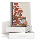 The Frog and Fungi greeting card by Red Cap Cards features whimsical, colorful mushrooms, plants, and a tiny figure. This illustrated card is printed in the USA and showcases a playful nature-inspired design.