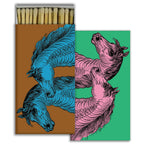HomArt's Match - Wild Horses features an open matchbox with mirrored blue horses on a brown cover. Next to it, a coordinating card shows pink horses on green—a unique and charming gift for any hostess.