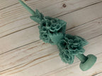 Beeswax Large Sage Oaxaca Marigold candle in sage green, adorned with sculpted flower blossoms.