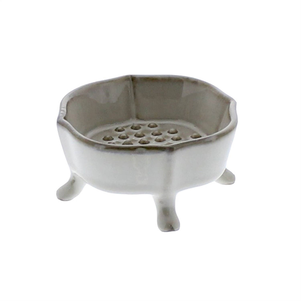 The HomArt Ceramic Rue Footed Soap Dish - Fancy White features four short legs and a raised, perforated platform for drainage—a stylish accessory that keeps your soap dry.
