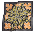 The No. 046 Amy Bandana by Handker Bandanas is a square black cotton scarf, hand screen-printed with large orange dogwood flowers, green leaves, and small white dots in a decorative symmetrical design. The fabric has a slightly wrinkled look.