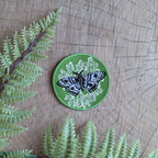 Add some flair with the ilikesara | art + goods iron-on patch featuring a green polyphemus moth resting on lichen.