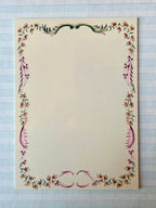 The Parcel French Menu Stationery Set II: 2 includes 8 blank cards on creamy white cardstock, each with a decorative floral border in green, orange, and purple—perfect for personal notes or menus.