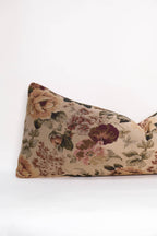 The Tapestry Long Lumbar by Twenty Third by Deanne is a rectangular pillow featuring a pink, green, and burgundy floral pattern on beige, shown on a plain white surface.