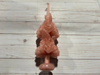 A pale pink handmade Rose Quartz Large Oaxaca Marigold Candle sculpted into the shape of two stacked marigold flowers.