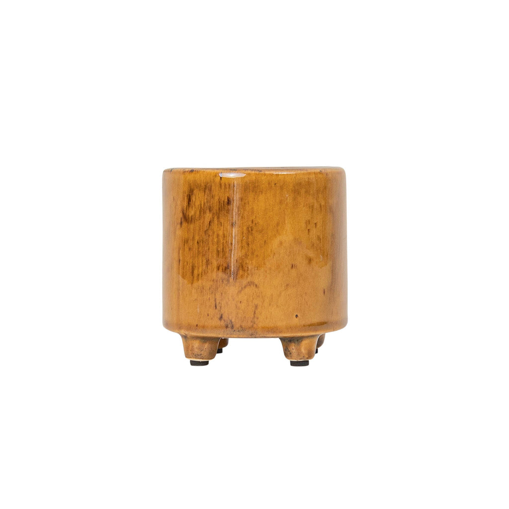 The Foreside Home & Garden Glossy Brown Ceramic Planter Pot is a small, cylindrical planter with a reactive glaze and three short legs, shown isolated on a white background.