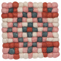 The Terra Dot Trivet by Danica Heirloom is a square woolen trivet made of felted balls in red, pink, cream, and green for a checkered geometric, eco-friendly accent to your kitchen.