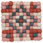 The Terra Dot Trivet by Danica Heirloom is a square woolen trivet made of felted balls in red, pink, cream, and green for a checkered geometric, eco-friendly accent to your kitchen.