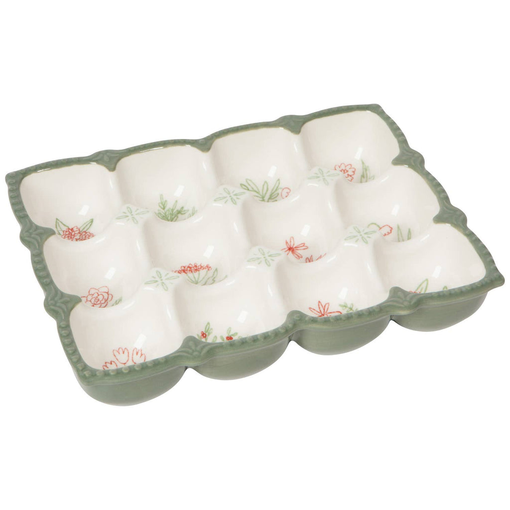 The Camellia Egg Holder by Danica Heirloom features a green-bordered floral design with twelve compartments—perfect for kitchen display and dishwasher safe for easy cleaning.