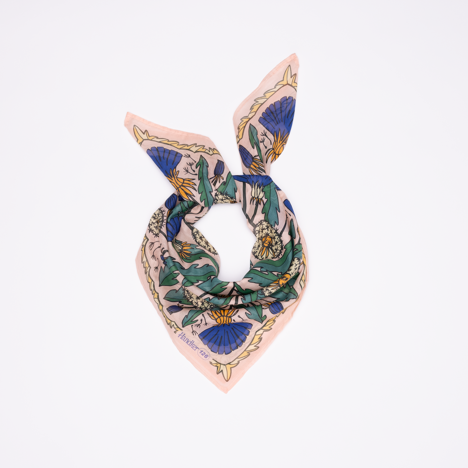 The Handker Bandanas 34" Dandy Wild Rag Bandana features a blue, green, and yellow floral print on light pink silk, styled with two pointed ends on a white background—ideal for pairing with premium cotton bandanas.