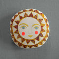 The Skippy Cotton Bright Neon Sun Pillow is a handmade, cotton-filled cushion featuring a stylized sun face with blue eyes, pink cheeks, and a vibrant yellow and red sunburst—perfect for whimsical home decor.