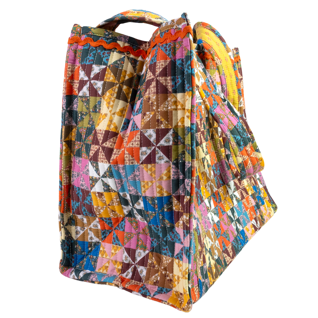 The Calico Quilted Tote by Handker Bandanas features a bright bandana cotton patchwork pinwheel design and small handles, shown on a white background.