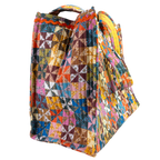 The Calico Quilted Tote by Handker Bandanas features a bright bandana cotton patchwork pinwheel design and small handles, shown on a white background.