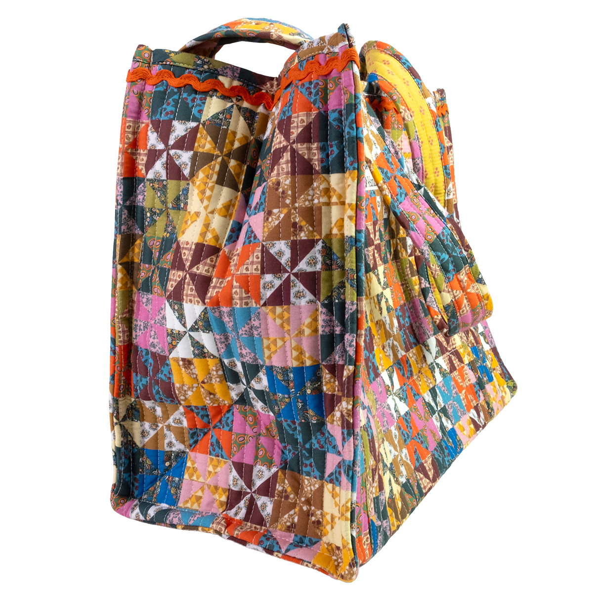 The Calico Quilted Tote by Handker Bandanas features a bright bandana cotton patchwork pinwheel design and small handles, shown on a white background.