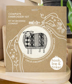The Sweater Weather Sheep Complete Embroidery Kit by Hook, Line & Tinker Embroidery Kits comes in a cardboard package with a black and white sheep illustration and includes a 6-inch embroidery hoop.