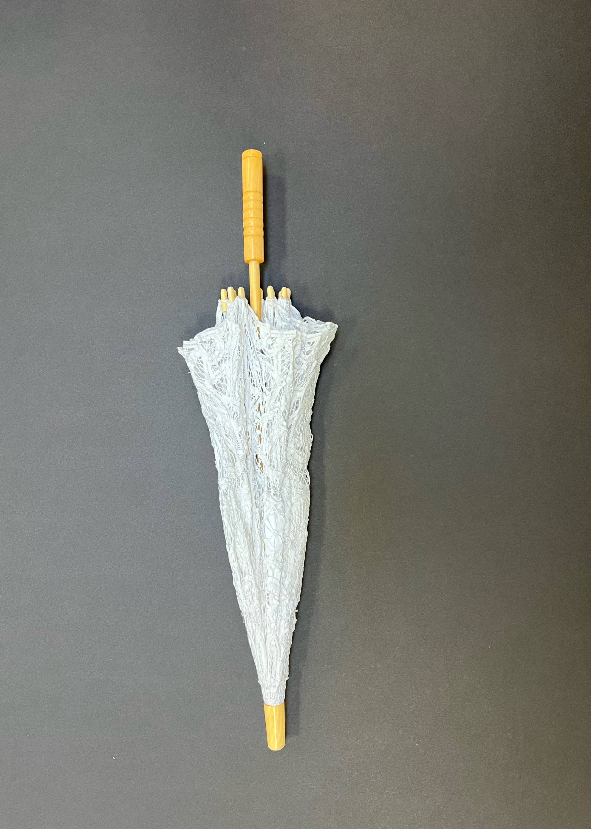 The Parasol - White by Peking Handicraft, featuring a Battenburg Victorian design with a wooden handle and tip, stands elegantly closed on a plain dark background.