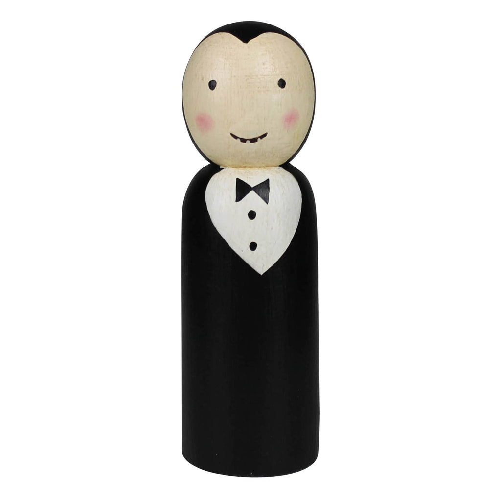 The HomArt Wood Vampire is a hand painted, carved wood peg doll with fangs, rosy cheeks, and a widow's peak. Dressed in a black suit and bow tie, it's perfect as charming Halloween decor.