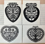 Papercut Heart Art Cards by Parcel: Set of four black, intricately designed, heart-shaped cards with animals and plants on white backgrounds. Each card is paired with a creamy white envelope and displayed on a tiled surface.
