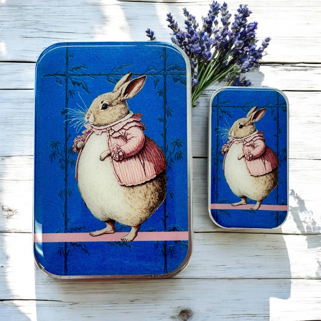 Firefly Notes’ Lady Bunbury, Bunny Notions Tin: Small features a hand-resined rabbit in a pink coat on a blue background, with matching rectangular tins and lavender on a white wooden surface.